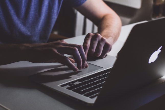 person touching open macbook on table 839465