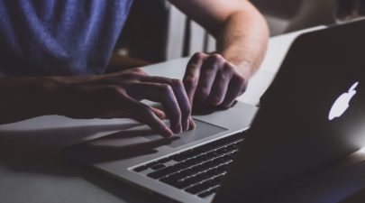 person touching open macbook on table 839465